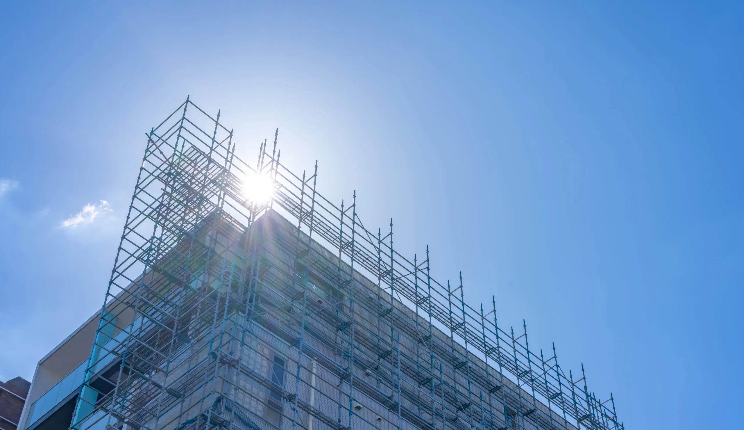 足場に覆われた建設中の建物を見上げたところ